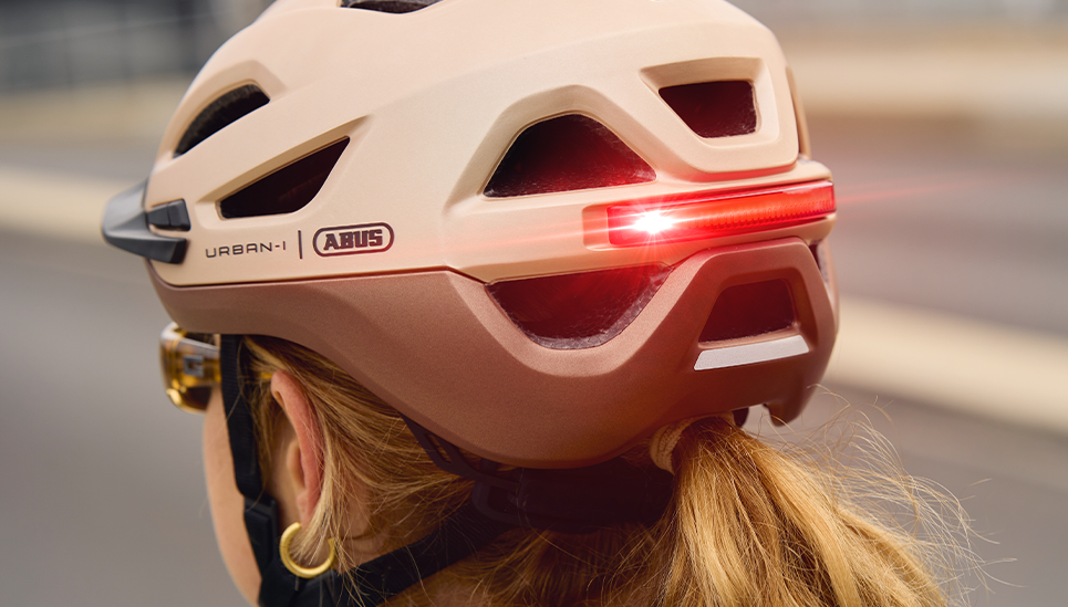 Az Urban-I 4.0 sisak LED-es hátsó lámpájának közeli felvétele, pezsgőarany színben © ABUS