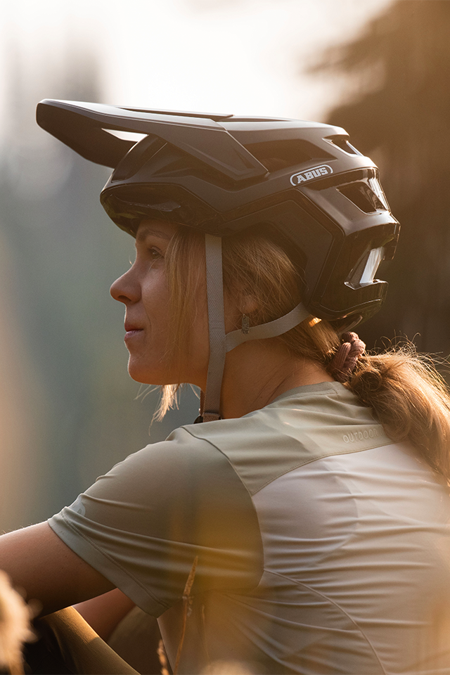 Mountain biker in warm evening light, wearing mtb helmet Targon © ABUS